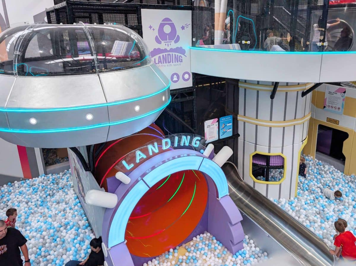NEW Landing Play Centre Altona North 2 Large spaceship-themed play structure with a tube slide and a “LANDING” tunnel entrance above a blue-and-white ball pit at Landing Play Centre Altona North.