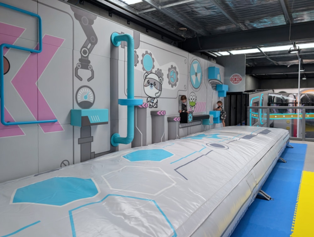 NEW Landing Play Centre Altona North 11 Wide view of a large inflatable landing mat in the space-themed play area at Landing Play Centre Altona North.